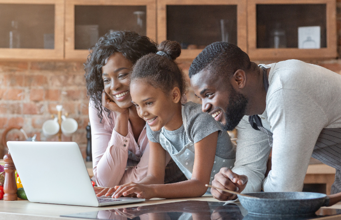  Family at the kitchen counter looking at laptop